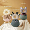 Three soft silicone head protection pillows shaped like a butterfly, frog, and little deer resting on a white draped surface.