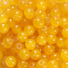 A close-up view of small, round, yellow glass beads for DIY jewelry making.