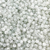 A close-up view of clear round glass crackle beads for jewelry making scattered in a pile.