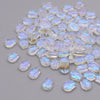 A pile of iridescent, translucent glass beads shaped like tulip flowers.