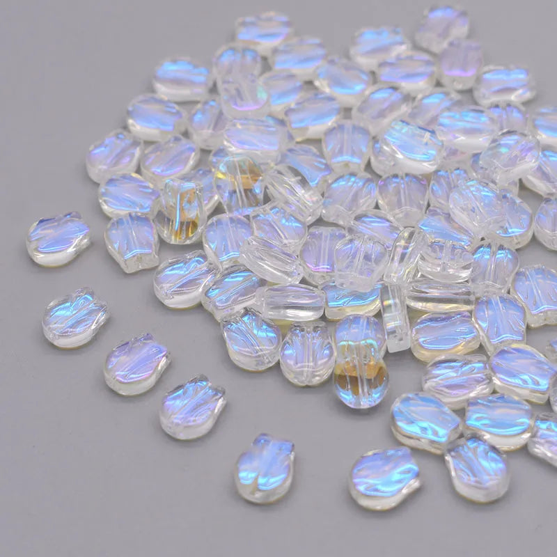 A pile of iridescent, translucent glass beads shaped like tulip flowers.