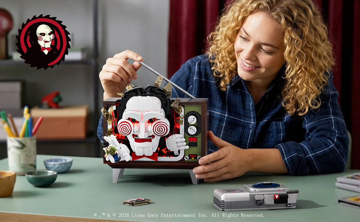 A woman is assembling a horror movie puppet model kit with a voice recorder on a green table.