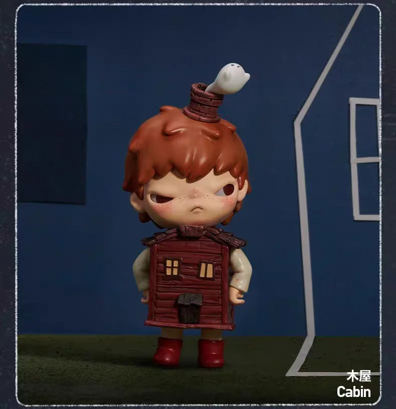 A collectible figurine of a small, reddish-brown skinned character wearing a hat and standing in front of a blue house.