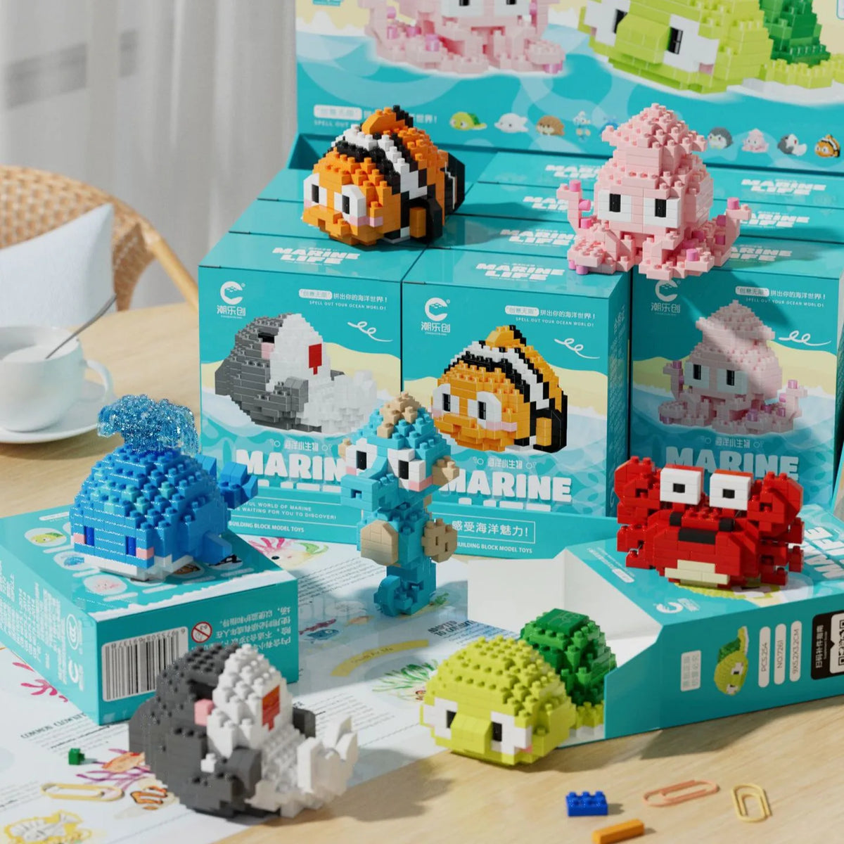 A collection of colorful penguin and sea animal 3D construction models in various sizes and colors displayed on a wooden surf