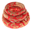A handmade red singing bowl cushion featuring intricate gold embroidery.