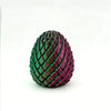 A close-up view of a green and purple textured dragon egg fidget spinner.