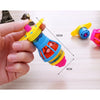 A hand holds a glowing spinning top toy with colorful parts and LED lights on a wooden surface.