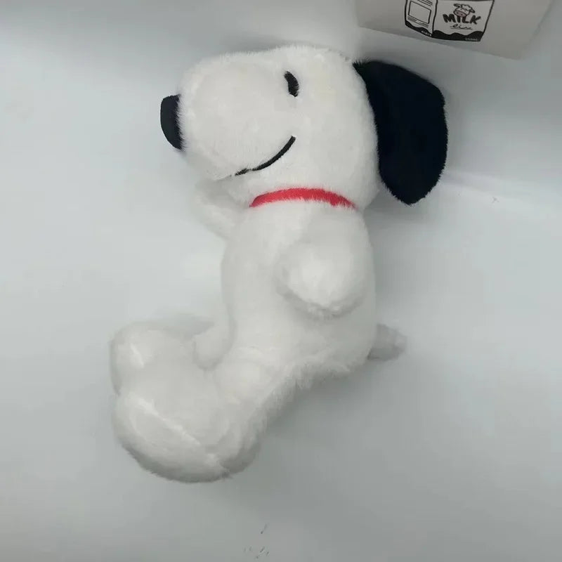 A white plush toy resembling Snoopy with black ears and a red collar is shown against a white background.