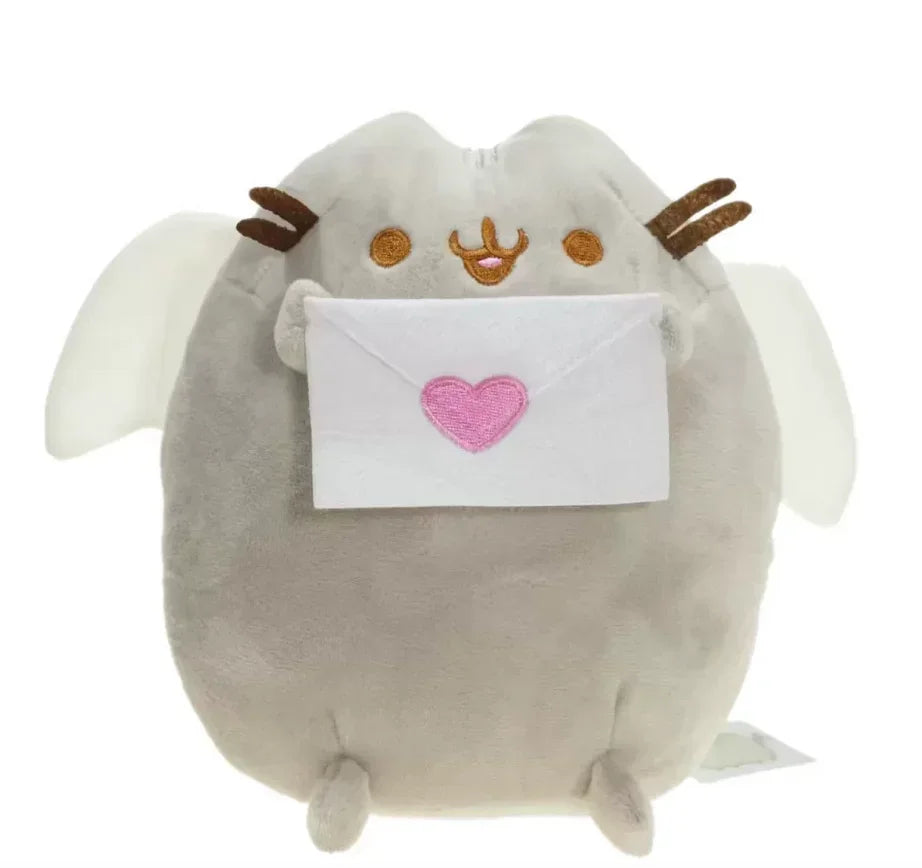 A soft gray plush cat toy with white wings holding a pink envelope.