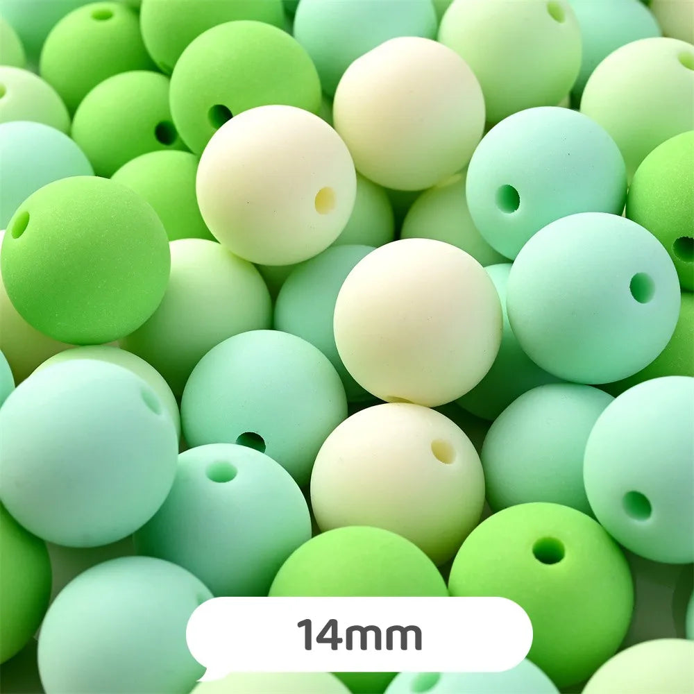 A close-up view of numerous pastel bear-shaped acrylic craft beads in various shades of green and cream.