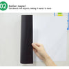 A hand is shown holding a black rubber magnet against a white dry erase board.