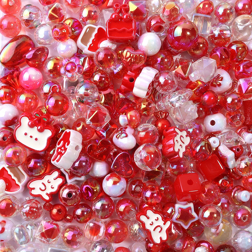 A close-up of small, colorful acrylic bow beads in various shades of red and pink scattered on a white surface.