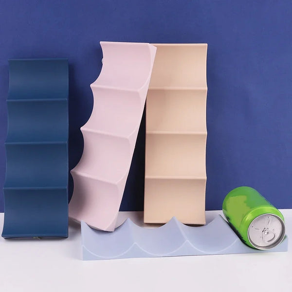 A stack of pink and beige plastic wine bottle storage racks resting on a light blue surface.