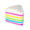 A white layer cake shaped squishy toy with colorful rainbow stripes and a speckled top.