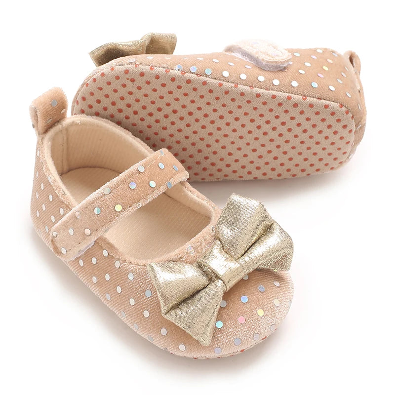 A pair of soft cotton baby walking shoes with anti-slip soles in a beige color.