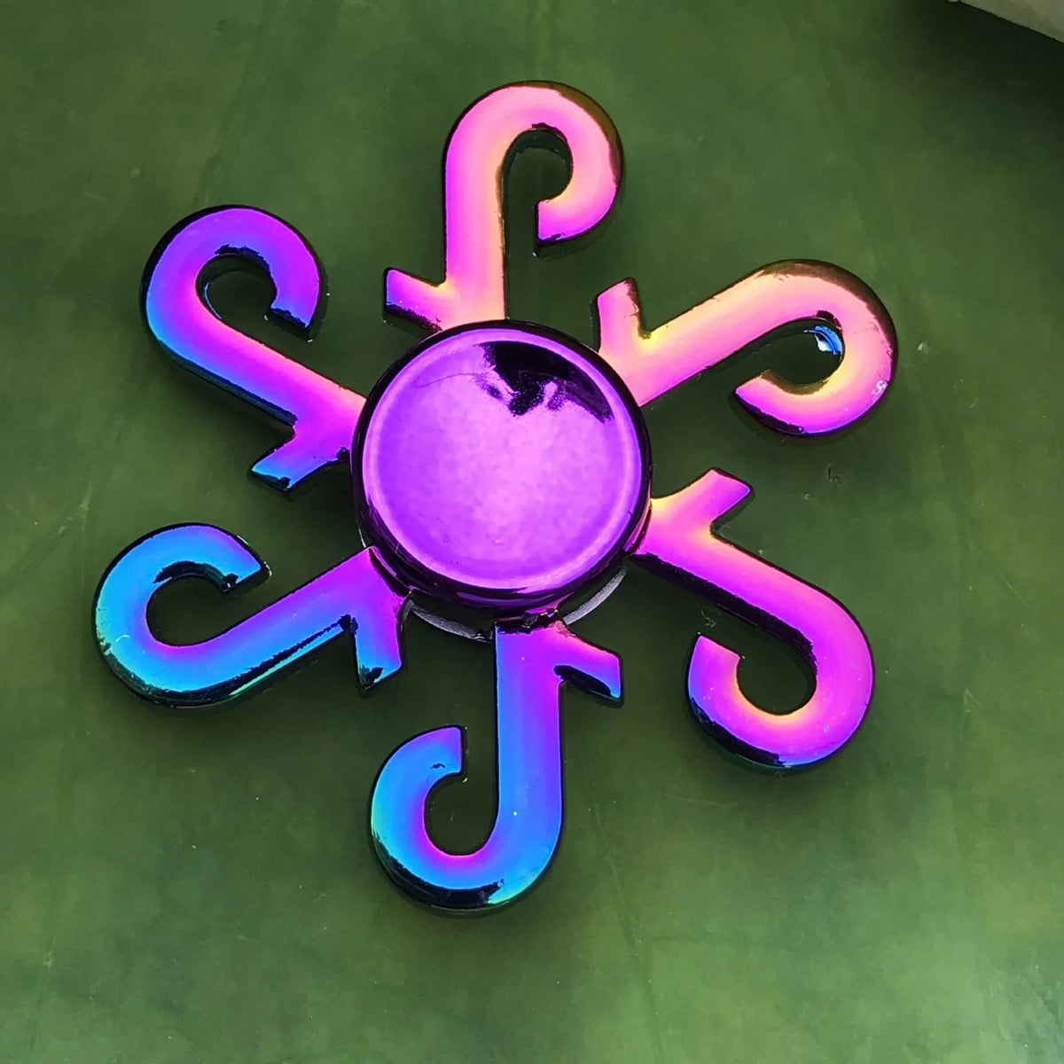 A rainbow metal fidget spinner with smooth silent rotation, featuring vibrant purple and blue colors.