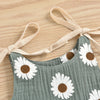 A gray cotton romper with a white daisy floral print and light beige adjustable straps