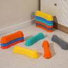 A set of colorful, non-slip sensory stepping stones in yellow, blue, green, and orange arranged on a light floor.