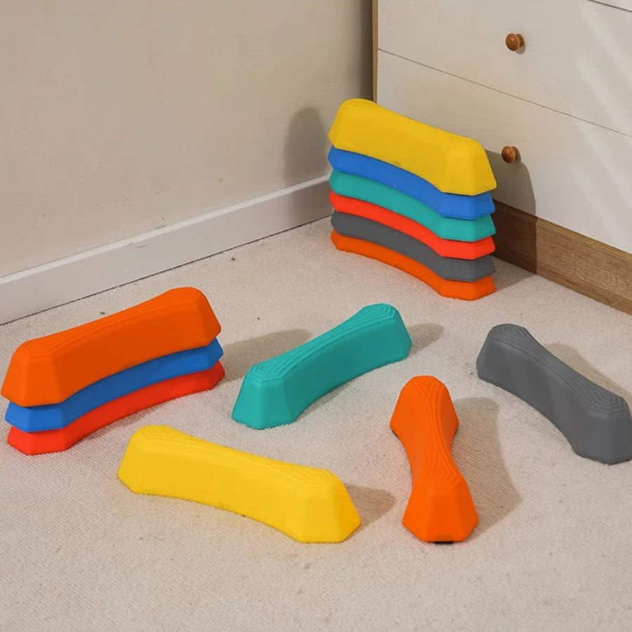A set of colorful, non-slip sensory stepping stones in yellow, blue, green, and orange arranged on a light floor.