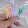 A hand holds five colorful ergonomic yarn guide rings for crochet and knitting.