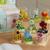 A collection of clear glass molds filled with colorful floral building blocks and flowers.