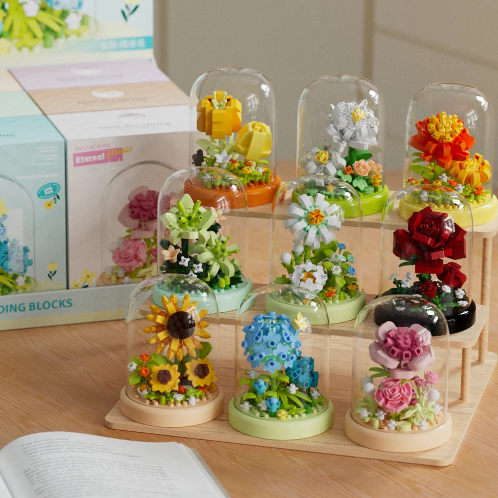 A collection of clear glass molds filled with colorful floral building blocks and flowers.