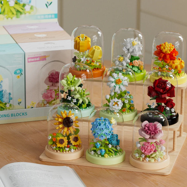 En samling klare glasforme fyldt med farverige blomsterbyggesten og blomster.