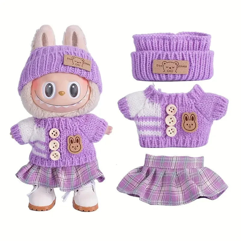 A set of purple and white knitted clothing for a doll figure including a hat, sweater, and skirt.
