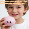 A young boy is smiling while holding a pink, squishy sensory compress toy.