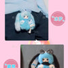A fluffy blue bunny plush toy with black ears and a small face is shown being held by a hand.
