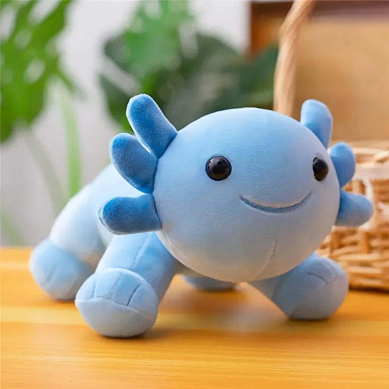 A soft blue axolotl plush toy with large eyes and fins sitting on a wooden surface.