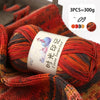 A close-up of a hand-knitted or crocheted scarf made from gradient orange, red, and brown acrylic yarn.