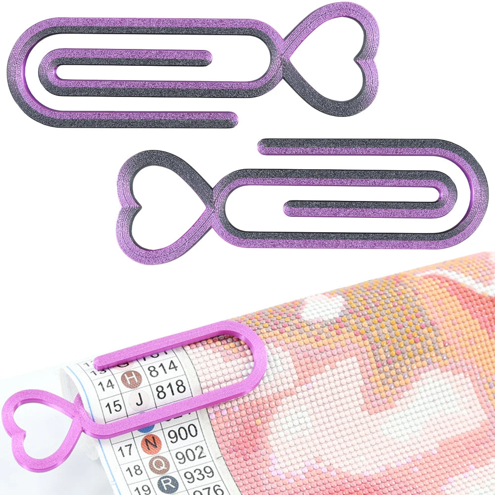 A set of two purple and gray heart-shaped clips used for diamond painting canvas