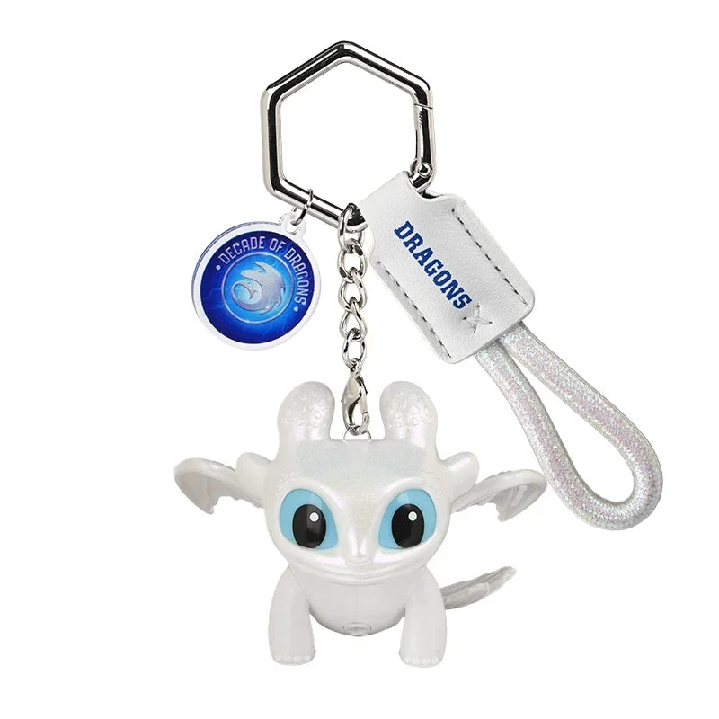 A white Toothless Dragon keychain featuring movable wings and glowing blue eyes.
