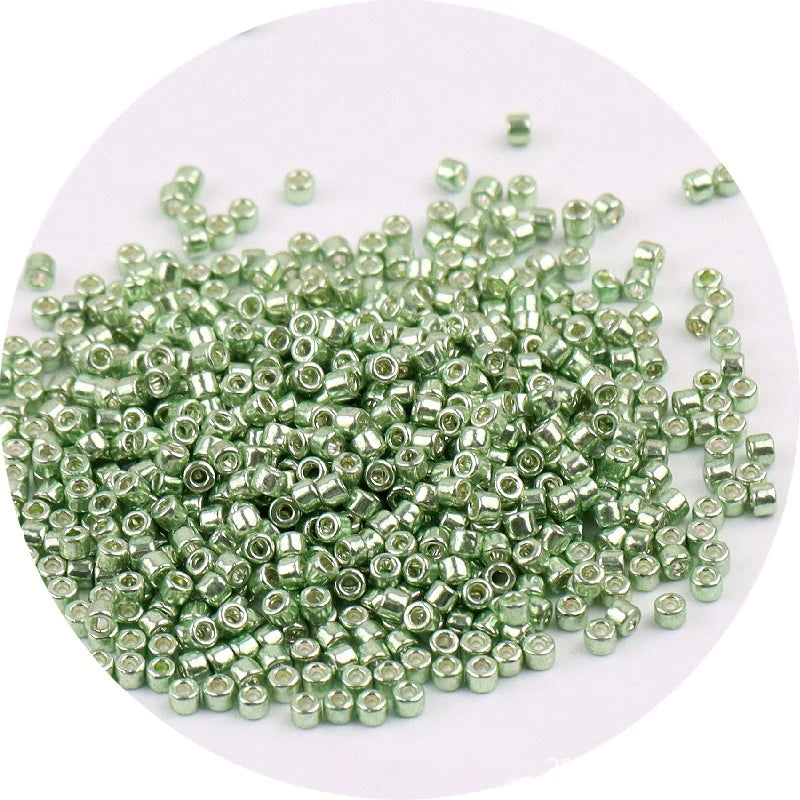 A pile of metallic glass beads, 2mm in size, packaged for jewelry making.