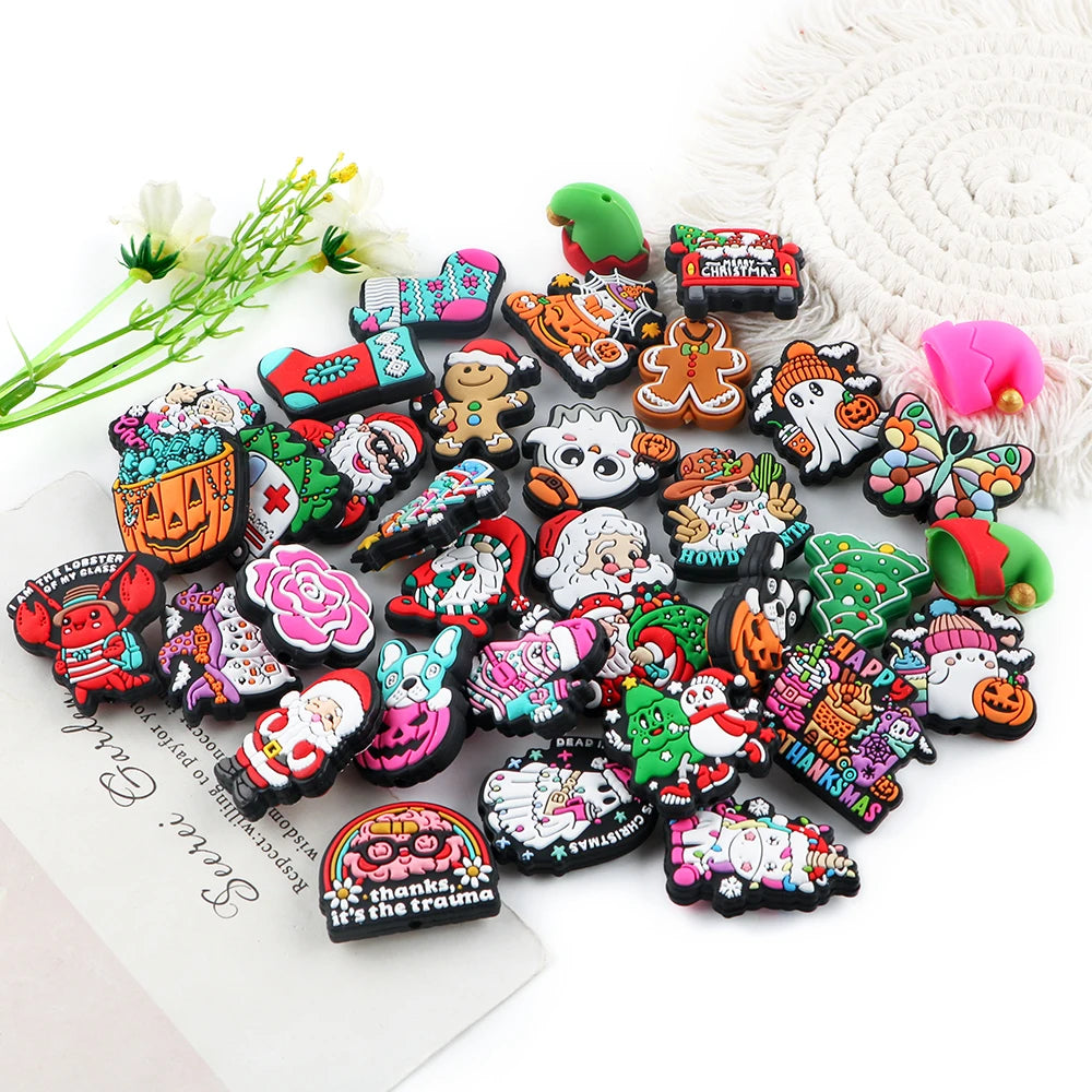 A collection of festive Christmas silicone beads and charms for jewelry making arranged on a white surface.