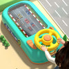 A child is interacting with a bright teal steering wheel driving toy that features a miniature road track.