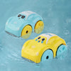 A yellow bath toy car with wheels is floating in blue water.