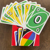 A fan of the FLIP! card game with a stack of matching cards in green and yellow colors.