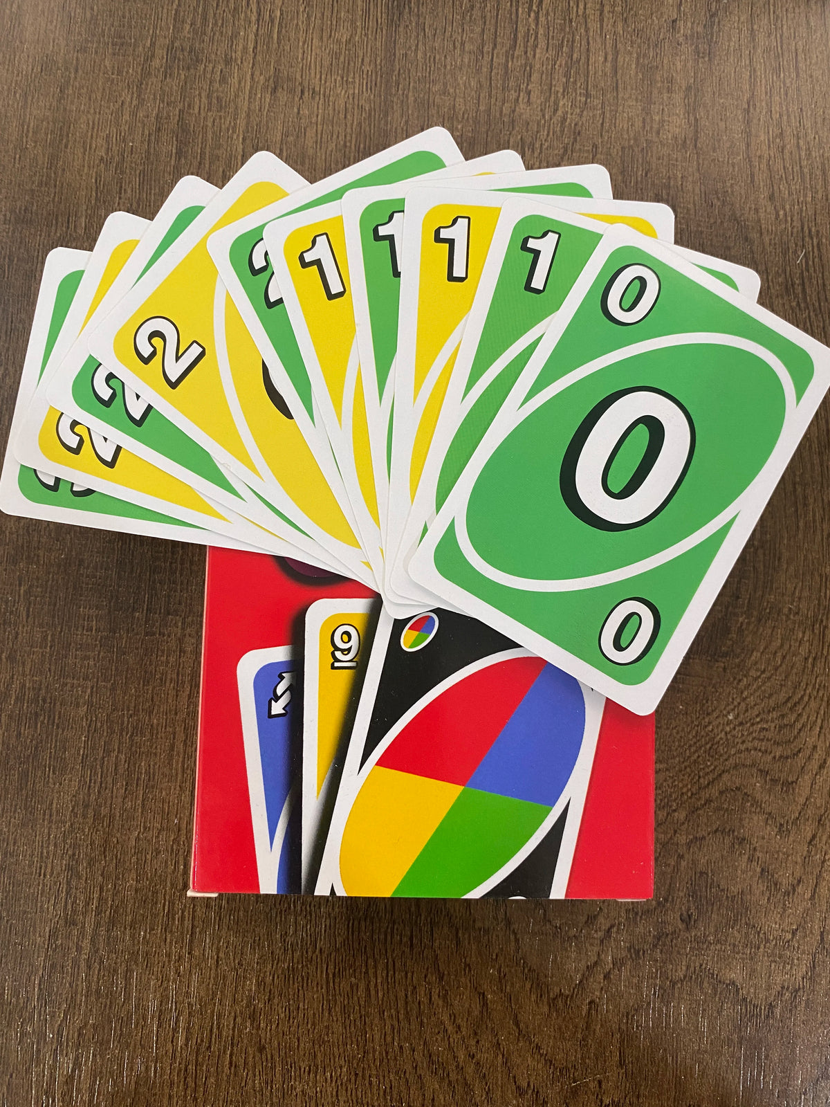 A fan of the FLIP! card game with a stack of matching cards in green and yellow colors.