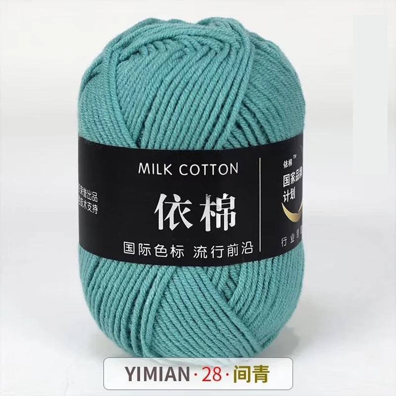 A ball of teal milk cotton yarn labeled YIMIAN 28 for knitting and crochet