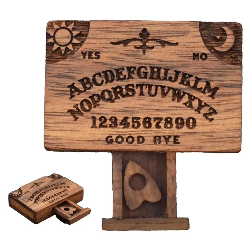 A wooden miniature Ouija board featuring an alphabet and yes no markings with a drawer.