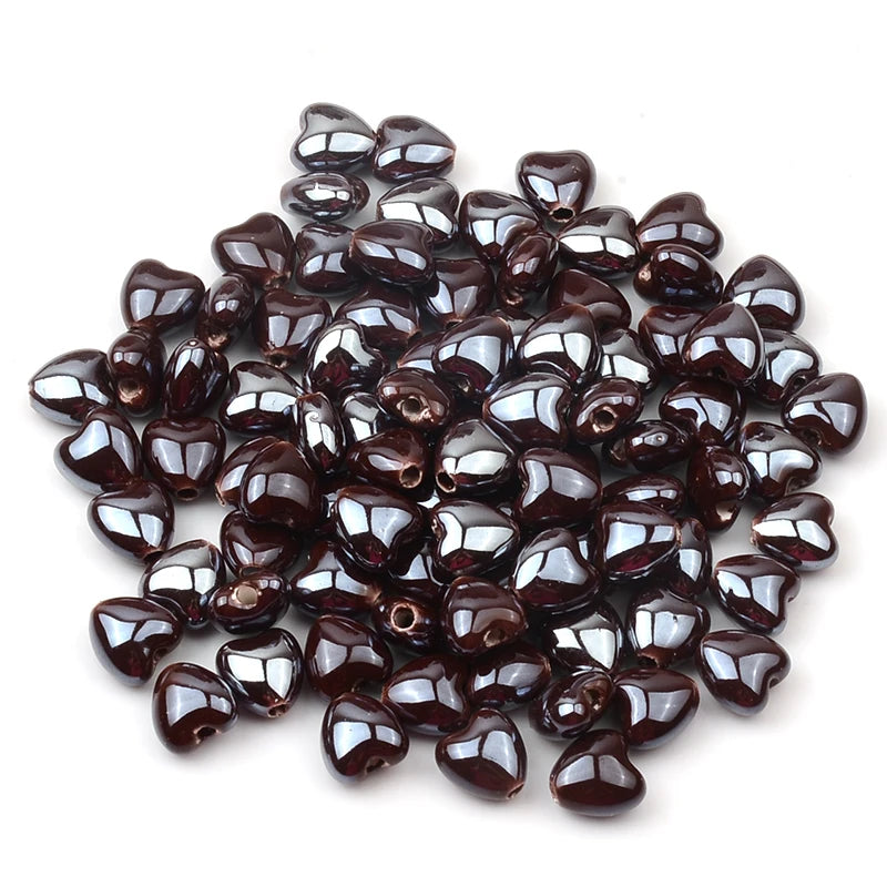 A pile of dark brown heart-shaped acrylic beads for jewelry making