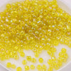 A pile of bright yellow glass rice beads for DIY jewelry and crafting.