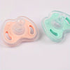 Two soft silicone baby pacifiers, one peach-colored and one mint green, shown side by side.