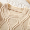 A beige knit sweater vest featuring a flower shape design and ruffled edges.