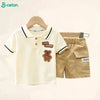 A beige boys' cotton summer short sleeve t-shirt and shorts set displayed on a wooden hanger.