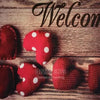 A collection of red felt hearts with white polka dots arranged on a wooden surface.