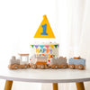 A wooden train set with numbered cars, including a large number one, displayed on a white cake.