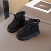 A pair of black kids' winter leather boots with laces and a brown cuff resting on a gray surface.